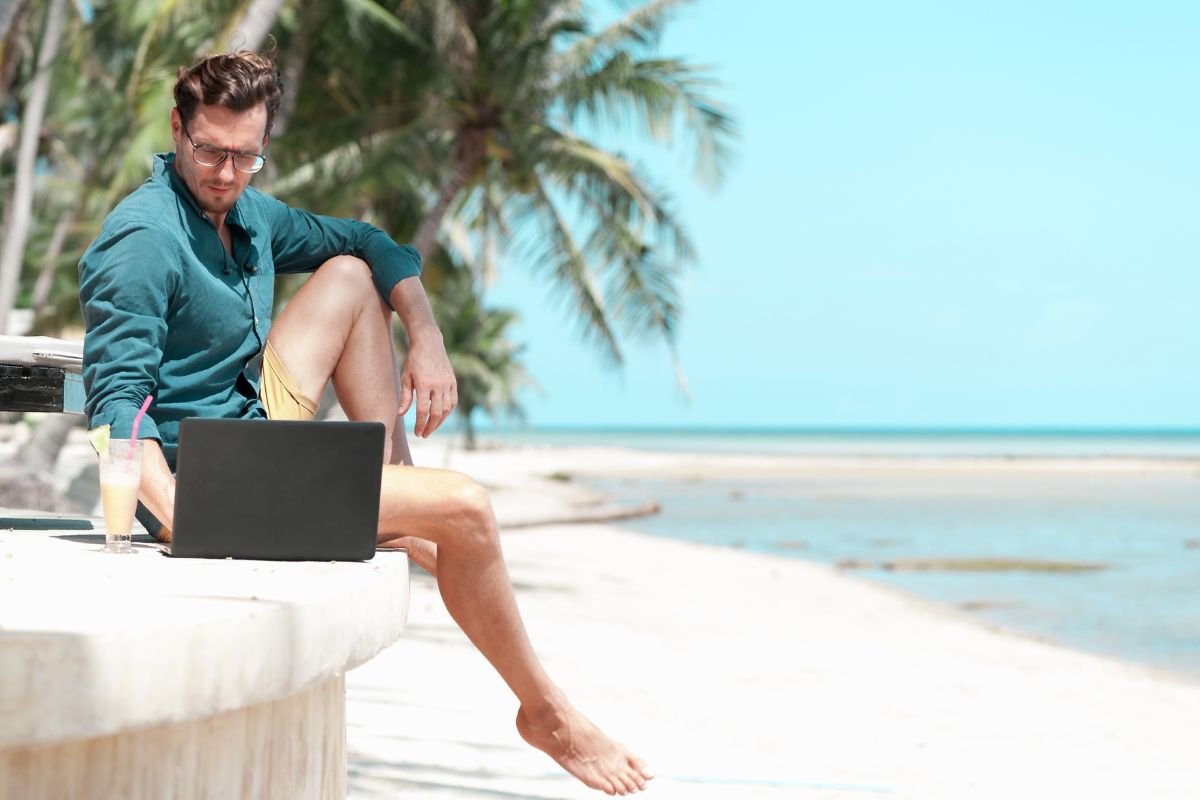 man on laptop by the beach